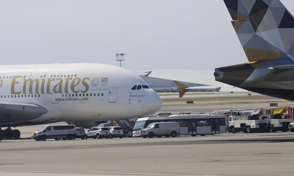 Emergency response crews gather outside a plane at JFK Airport amid reports of ill passengers aboard a flight from Dubai on Wednesday Sept. 5, 2018, in New York. (AP Photo/Bebeto Matthews)