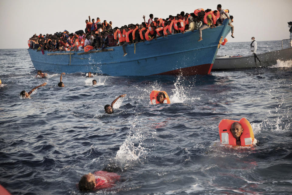 FILE - In this Monday, Aug. 29, 2016 file photo, migrants, most of them from Eritrea, jump into the water from a crowded wooden boat as they are helped by members of an NGO during a rescue operation at the Mediterranean sea, about 13 miles north of Sabratha, Libya. On Friday, July 5, 2019, Libya's interior minister, Fathi Bashagha, pleaded Friday for Europe "to address the problem in a radical way _ not to prevent migrants, but to provide jobs and investment in the migrants' places of origin, as well as in southern Libya ... so as to absorb these huge numbers willing and eager to migrate to Europe." (AP Photo/Emilio Morenatti)