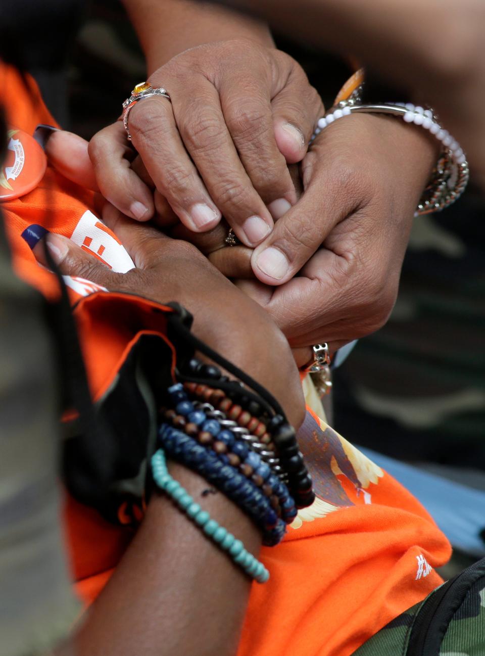 Two women hold hands as Mothers of Murdered Columbus Children held an anti-gun violence rally and march at Columbus City Hall in August.