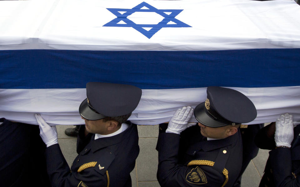 Members of the Knesset guard carry the coffin of late Israeli Prime Minister Ariel Sharon at the Knesset, Israel's Parliament, in Jerusalem, Sunday, Jan. 12, 2014. Sharon, the hard-charging Israeli general and prime minister who was admired and hated for his battlefield exploits and ambitions to reshape the Middle East, died Saturday, eight years after a stroke left him in a coma from which he never awoke. He was 85. (AP Photo/Sebastian Scheiner)