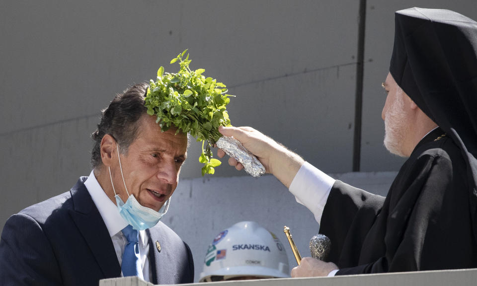 New York Gov. Andrew Cuomo, left, is blessed by Archbishop Elpidophoros holding sprigs of basil during a ceremony at the St. Nicholas Greek Orthodox Church, Monday, Aug. 3, 2020 at the World Trade Center in New York. The original church was destroyed in the attacks of Sept. 11, 2001. The shrine is expected to open in 2021. (AP Photo/Mark Lennihan)