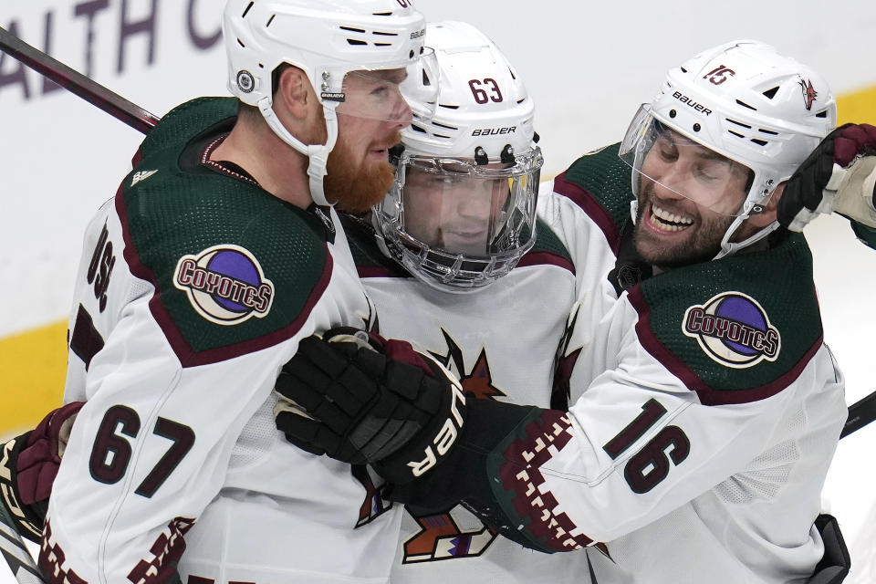Arizona Coyotes' Matias Maccelli (63) celebrates his goal with Lawson Crouse (67) and Jason Zucker (16) during the first period of an NHL hockey game against the Pittsburgh Penguins in Pittsburgh, Tuesday, Dec. 12, 2023. (AP Photo/Gene J. Puskar)