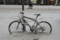 A bicycle is pictured covered with snow during a snow storm in Times Square in the Manhattan borough of New York, January 23, 2016. REUTERS/Carlo Allegri