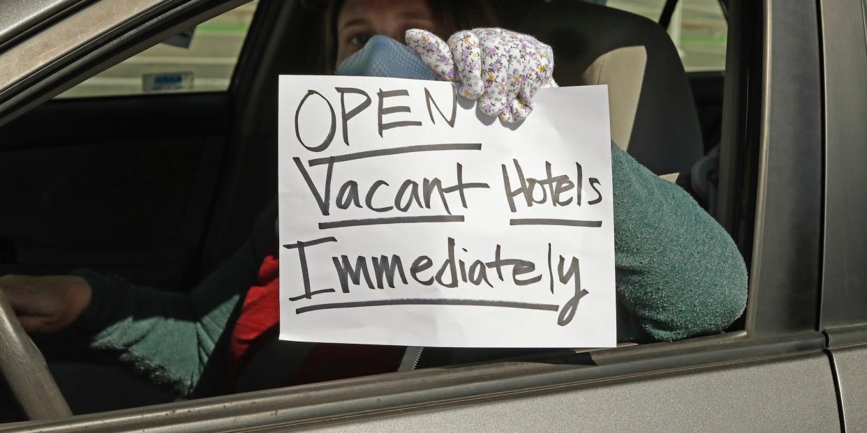An activist protests from her vehicle calling to house homeless people using vacant hotels.