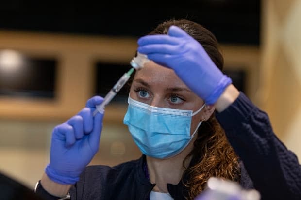 Registered nurse Sarah Moslehi prepares a dose of the Pfizer-BioNTech COVID-19 vaccine at a temporary clinic at the Woodbine racetrack and casino, in northeast Toronto, on May 5, 2021. (Evan Mitsui/CBC - image credit)