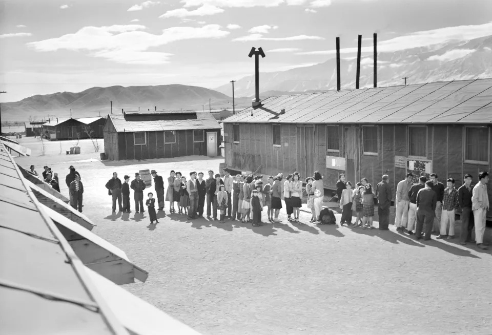 Japoneses estadounidenses esperando una fila en el centro de reubicación de Mass Hall, en Manzanar, California. Archive/Universal Images Group via Getty Images)