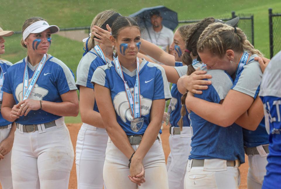 Deltona's Jaylene Mieres (3), center, stands with her teammates in the rain after the Class 5A state championship game in Clermont on Thursday.