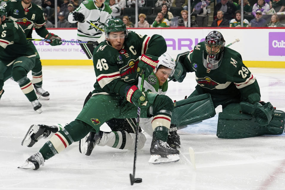 Minnesota Wild goalie Marc-Andre Fleury (46) clears the puck away from Dallas Stars center Joe Pavelski, center, as goalie Marc-Andre Fleury looks on during the second period of an NHL hockey game, Sunday, Nov. 12, 2023, in St. Paul, Minn. (AP Photo/Craig Lassig)