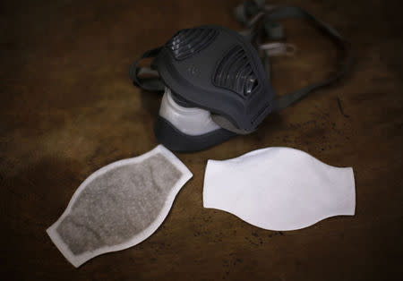 Liu Ke's mask, a new filter (R) and a used filter which he had used for two weeks are seen on a table in Beijing December 19, 2014. Liu rides a bicycle almost everyday to avoid Beijing's congested traffic. He said it is necessary for him to wear a mask when air pollution levels increase to protect himself. REUTERS/Kim Kyung-Hoon