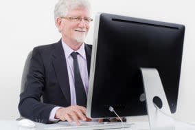 senior businessman with computer over white