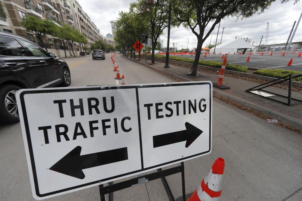 Traffic flows around a sign placed near the entrance of a coronavirus test location in Dallas, Tuesday, March 31, 2020. For most people, the coronavirus causes mild or moderate symptoms, such as fever and cough that clear up in two to three weeks. For some, especially older adults and people with existing health problems, it can cause more severe illness, including pneumonia and death. (AP Photo/Tony Gutierrez)