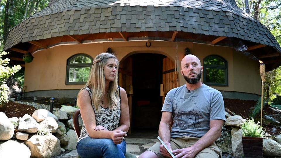 Rod Collen and his fiancé, Shannon Garrett, sit in front of their mushroom-shaped house that they built from the ground up together on their property in Lakebay, Wash. August 13, 2022. The couple spoke with The News Tribune for an article about the home near Penrose State Park.