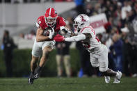 Georgia tight end Brock Bowers (19) runs after a catch as Mississippi safety Nick Cull (29) defends during the first half of an NCAA college football game, Saturday, Nov. 11, 2023, in Athens, Ga. (AP Photo/John Bazemore)
