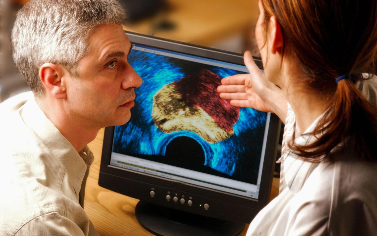 A posed photo representing a doctor examining a cancer scan