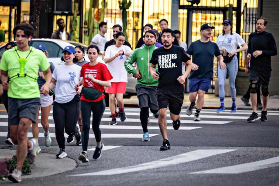 A group of people running in a crosswalk