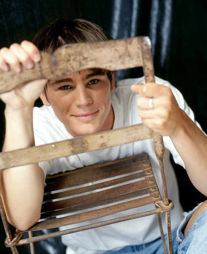 he's looking through the opening of a chair