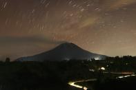 Mount Sinabung spews ash and smoke as it is pictured from Tiga Pancur village in Karo district, Indonesia's north Sumatra province, November 4, 2013. A volcano erupted for the third time in as many months on the western Indonesian island of Sumatra, forcing hundreds of villagers to evacuate, officials said. Mount Sinabung spewed a 7-km (4.3-mile) column of ash into the air on Sunday, prompting authorities to impose a 3-km evacuation radius. Picture taken November 4, 2013. REUTERS/Roni Bintang (INDONESIA - Tags: DISASTER ENVIRONMENT)