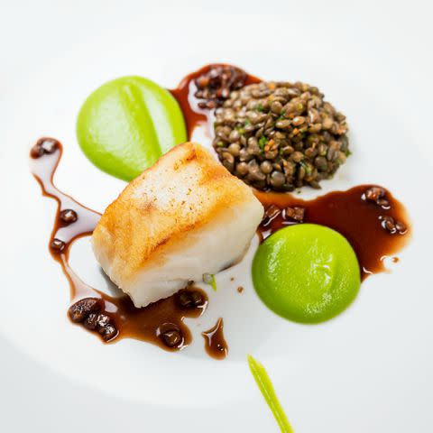 <p>Xavier Buendia</p> Cod with pea puree, Puy lentils, and red wine sauce at The Little Fish Market in Brighton.