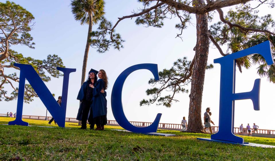 New College graduates Rae Thompson and Phynyx Soltis-Tatro pose for photos before their graduation ceremony in Sarasota on May 17.