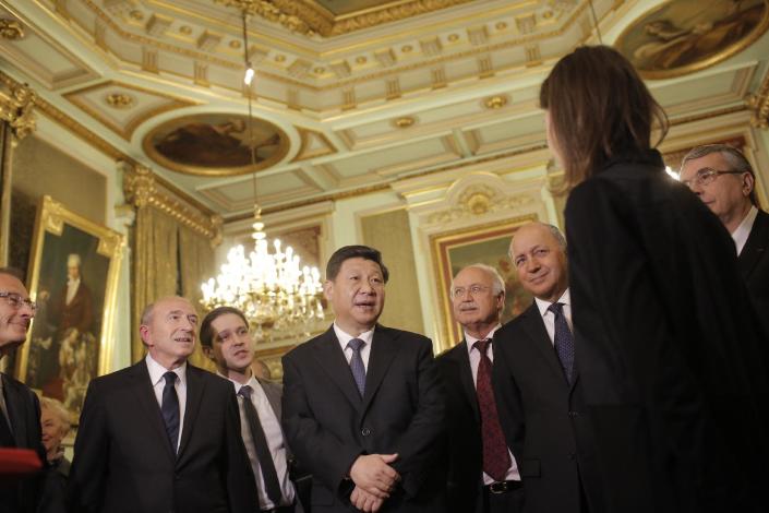 Chinese President Xi Jinping, center, Lyon's mayor Gerard Collomb, left, and French foreign minister Laurent Fabius, second right, listen to a local unidentified businessman before a dinner at the town hall in Lyon, central France, Tuesday, March 25, 2014. Xi Jinping arrived in France for a three-day state visit. (AP Photo/Laurent Cipriani, Pool)