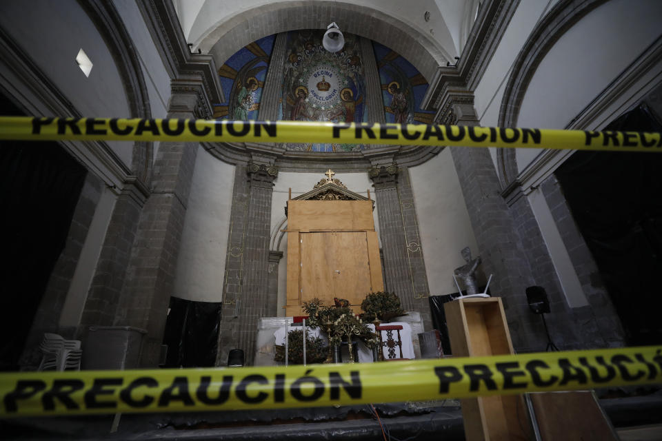 Cintas amarillas impiden el acceso al ábside de la iglesia de Nuestra Señora de los Ángeles, en la Ciudad de México, que está siendo restaurada tras sufrir severos daños en el terremoto del 2017. Una estructura de madera protege un cuadro de hace 400 años. Foto del 6 de octubre del 2020. (AP Foto/Rebecca Blackwell)