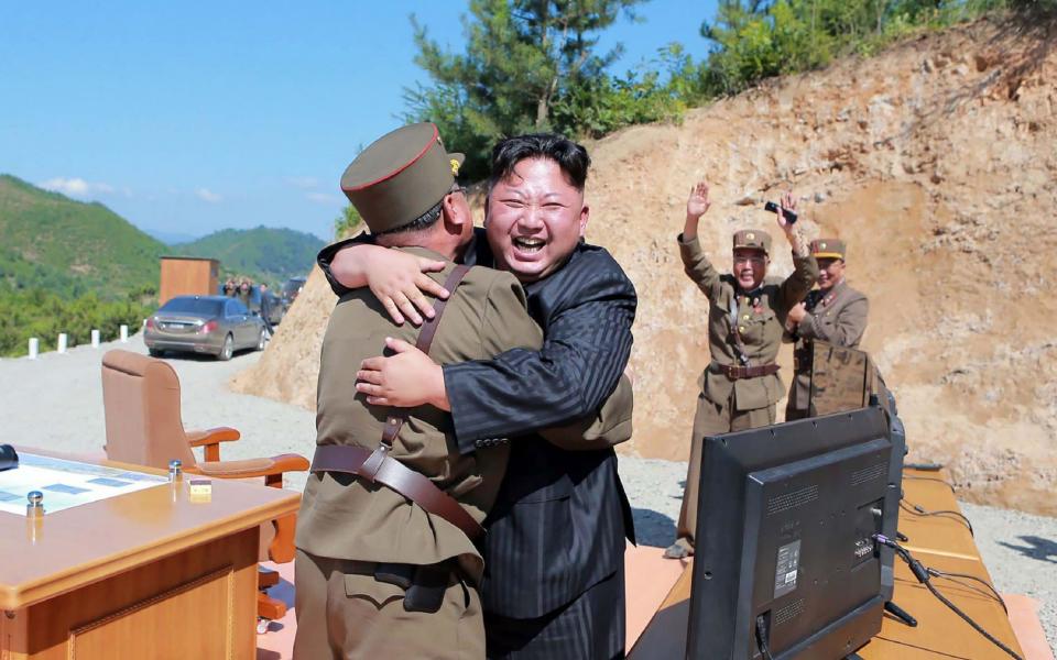 North Korean leader Kim Jong-Un celebrating the successful test-fire of the intercontinental ballistic missile Hwasong-14 at an undisclosed location - Credit: AFP / KCNA