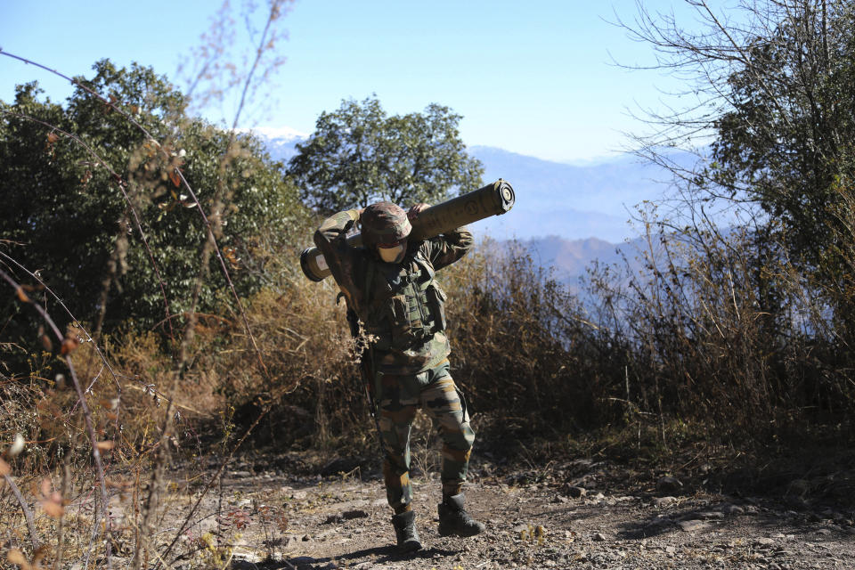 An Indian army soldier carries an anti-tank guided missile (ATGM) to his base between India and Pakistan border on the forward post of Balakot, in Poonch, about 250 kilometers (156 miles) from Jammu, India, Friday, Dec.18, 2020. AP journalists were recently allowed to cover Indian army counterinsurgency drills in Poonch and Rajouri districts along the Line of Control. The training focused on tactical exercises, battle drills, firing practice, counterinsurgency operations and acclimatization of soldiers to the harsh weather conditions. (AP Photo/Channi Anand)