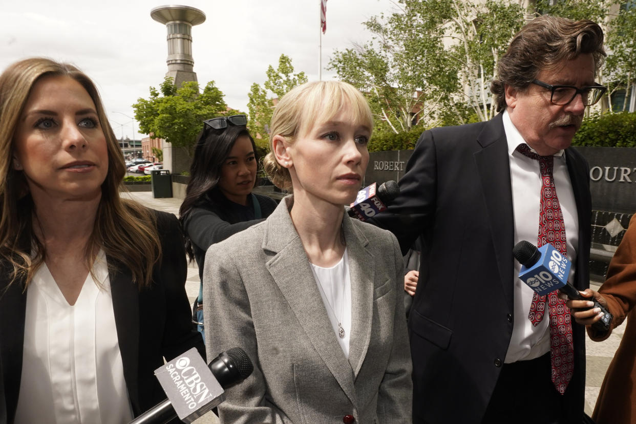 FILE - Sherri Papini of Redding walks to the federal courthouse accompanied by her attorney, William Portanova, right, in Sacramento, Calif., Wednesday, April 13, 2022. Papini is scheduled to appear in federal court, Monday, Sept. 19, 2022, where prosecutors are asking that she be sentenced to eight months in prison for faking her own kidnapping in 2016. (AP Photo/Rich Pedroncelli, File)