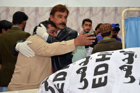 A paramedic staff comforts a relative after a police officer and three of his family members were shot dead in Quetta, Pakistan November 15, 2017. REUTERS/Naseer Ahmed