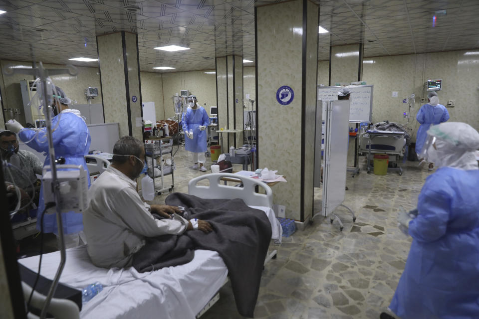 Nurses treat patients infected with the coronavirus in the intensive care unit at the Syrian American Medical Society Hospital, in the city of Idlib, northwest Syria, Monday, Sept. 20, 2021. Coronavirus cases are surging to the worst levels of the pandemic in Idlib province, a rebel stronghold in Syria — a particularly devastating development in a region where scores of hospitals have been bombed and that doctors and nurses have fled in droves during a decade of war. (AP Photo/Ghaith Alsayed)