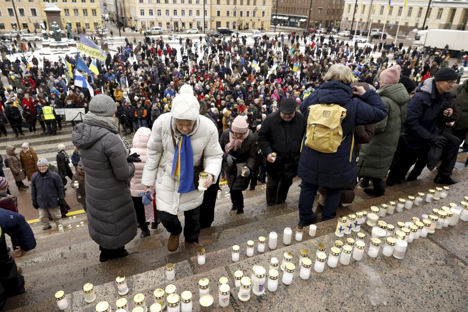 People place candles on the steps of the Helsinki Cathedral at the Light for Ukraine candlelight memorial event for Ukraine war victims at the Senate Square in Helsinki, Friday, Feb. 24, 2023. (Roni Rekomaa/Lehtikuva via AP)
