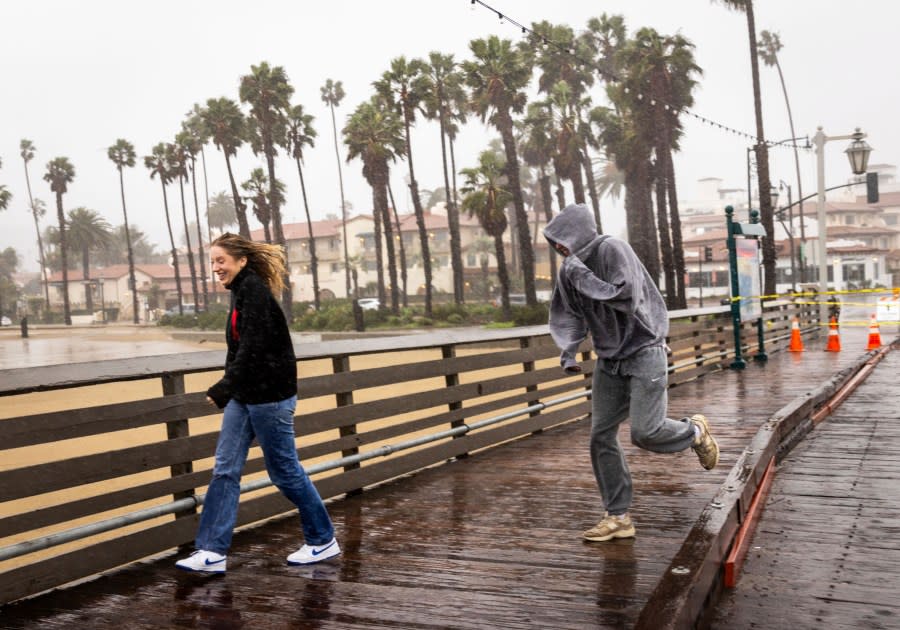 Pedestrians are caught out in a rainstorm, Sunday, Feb. 4, 2024, in Santa Barbara, Calif. (AP Photo/Ethan Swope)