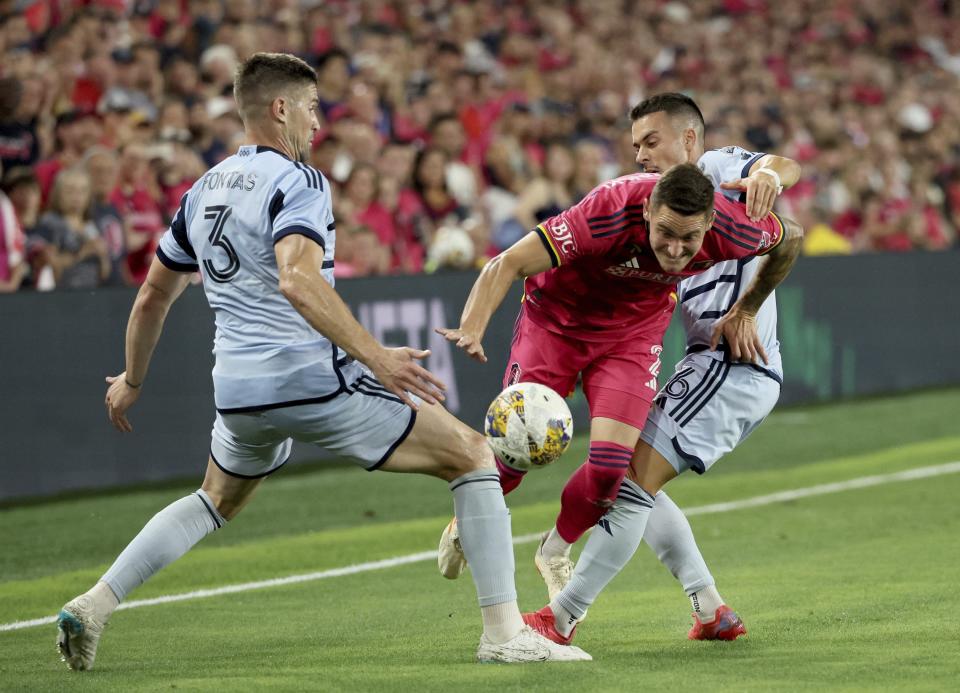 Sporting Kansas City's Andreu Fontàs, left, and Erik Thommy, right, squeeze St. Louis City SC defender Jake Nerwinski, center, on his run to goal during the first half of an MLS soccer match in St. Louis on Saturday, Sept. 30, 2023. (David Carson/St. Louis Post-Dispatch via AP)