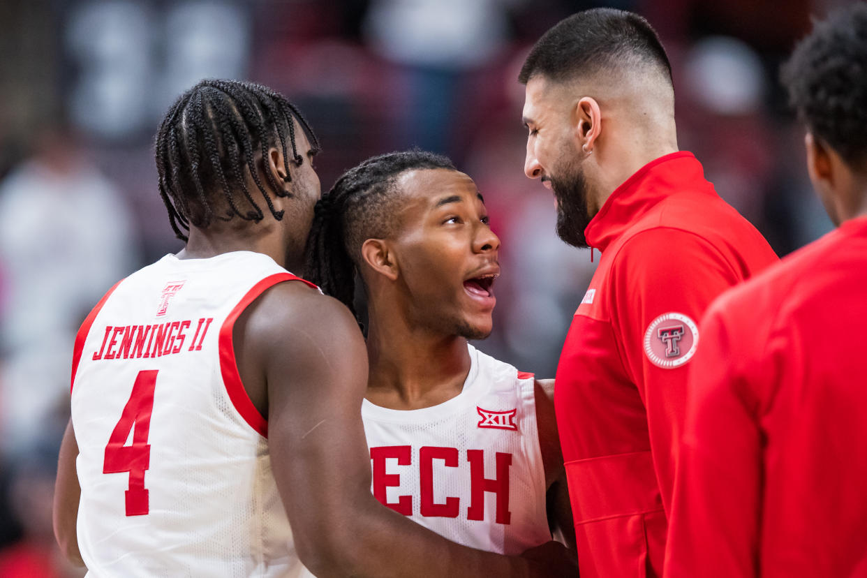 LUBBOCK, TEXAS - JANUARY 07: Guard Lamar Washington #1 of the Texas Tech Red Raiders celebrates with forward Robert Jennings #4 and Fardaws Aimaq during the second half of the college basketball game against the Oklahoma Sooners at United Supermarkets Arena on January 07, 2023 in Lubbock, Texas. (Photo by John E. Moore III/Getty Images)