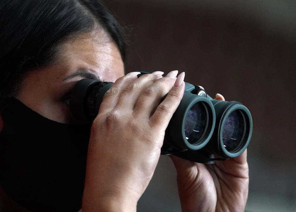 A reporter watches the Maricopa County ballots cast in the 2020 general election being examined and recounted by contractors working for Florida-based company, Cyber Ninjas, who was hired by the Arizona State Senate at Veterans Memorial Coliseum in Phoenix, Thursday, April 29, 2021. (Rob Schumacher/The Arizona Republic via AP, Pool)