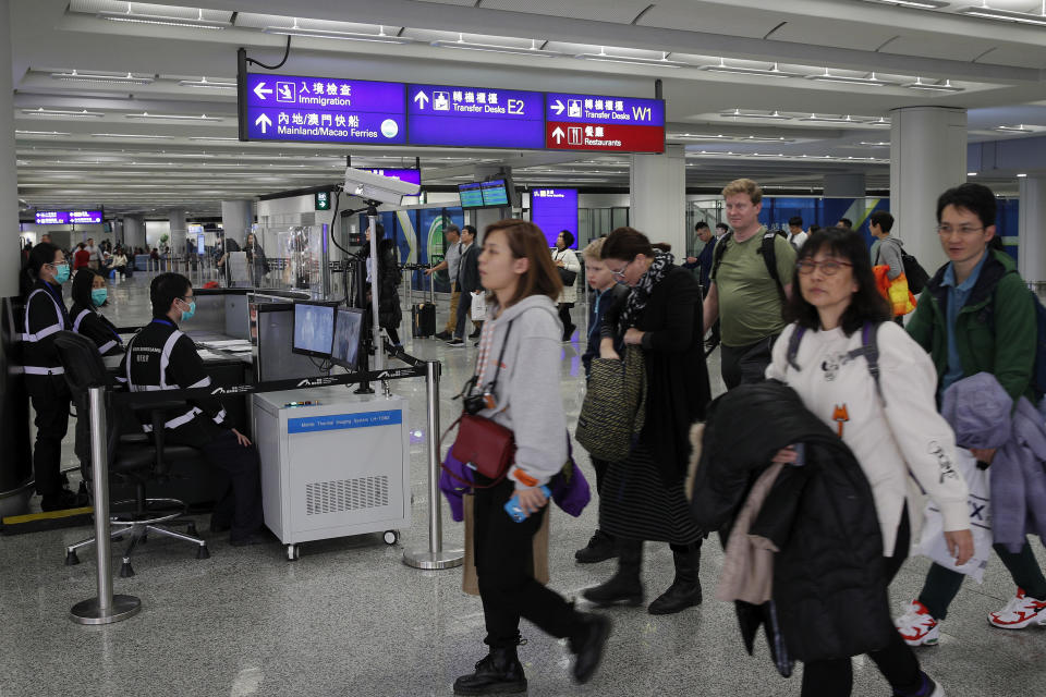 Health surveillance officer use temperature scanner to monitor passengers arriving at the Hong Kong International airport in Hong Kong, Saturday, Jan. 4, 2020. Hong Kong authorities activated a newly created "serious response" level Saturday as fears spread about a mysterious infectious disease that may have been brought back by visitors to a mainland Chinese city. (AP Photo/Andy Wong)