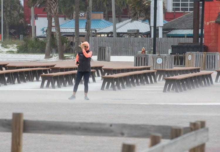 Mihaela Girbacica, of Omaha, Nebraska, braces against the strong wind at Casino Beach as a storm approaches the Pensacola area on April 10, 2024.