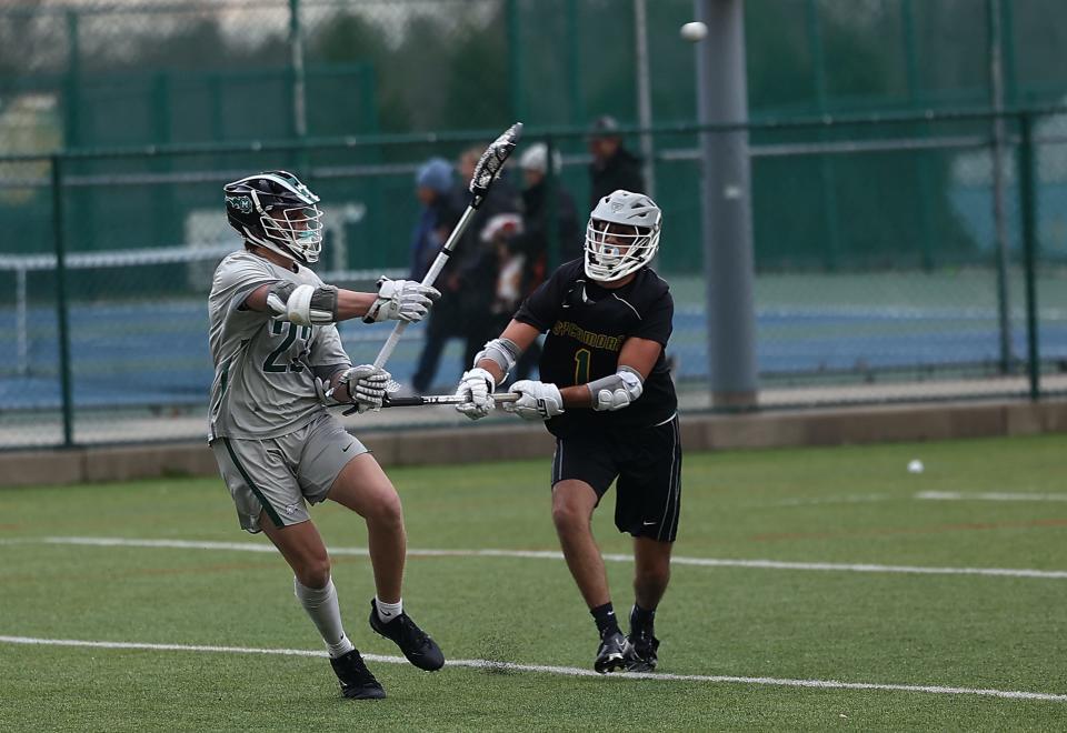 Mason's Weston Simmons (22) shoots over Sycamore's Seth Truter (21) during their lacrosse match Thursday, April 7, 2022.