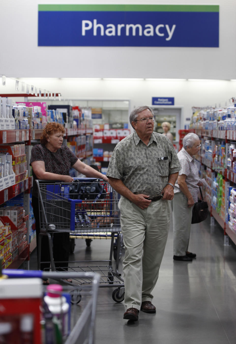 Customers shop in the pharmacy section of a Sam's Club store, a division of Wal-Mart Stores in Bentonville, Arkansas June 4, 2009. Warehouse club operators like Sam's Club charge consumers an annual fee to shop in their stores and offer discounts on everything from flat-screen TVs to printer paper to beef tenderloin.   REUTERS/Jessica Rinaldi (UNITED STATES BUSINESS HEALTH)