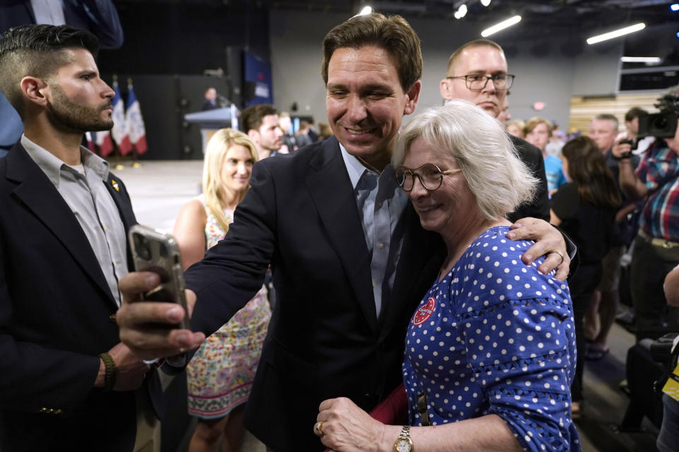 Republican presidential candidate Florida Gov. Ron DeSantis poses for a photo with Bette Guzman, of West Des Moines, Iowa, during a campaign event, Tuesday, May 30, 2023, in Clive, Iowa. (AP Photo/Charlie Neibergall)