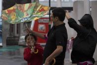 A child holds an inside-out umbrella broken due to strong winds before Typhoon Usagi is expected to make landfall, in Hong Kong September 22, 2013. Hong Kong was bracing on Sunday for this year's most powerful typhoon, with government meteorologists warning of severe flooding created by a double whammy of powerful winds and exceptionally high tides. REUTERS/Tyrone Siu (CHINA - Tags: ENVIRONMENT DISASTER SOCIETY)