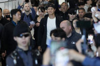 Los Angeles Dodgers Shohei Ohtani, center, walks with his wife Mamiko Tanaka, center left, through a terminal during the baseball team's arrival at Incheon International Airport, Friday, March 15, 2024, in Incheon, South Korea, ahead of the team's baseball series against the San Diego Padres. (AP Photo/Ahn Young-joon)