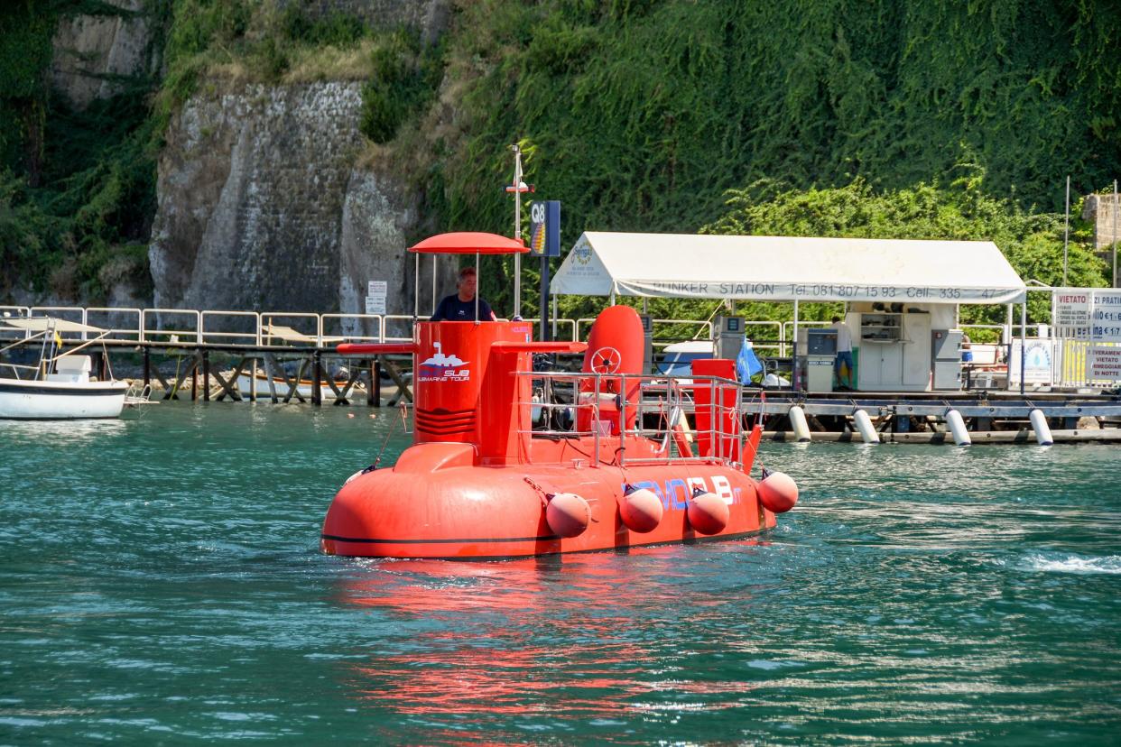 Sorrento, Italy - August 2019:  Small red submarine in Sorrento harbour. It offers trips to tourists,