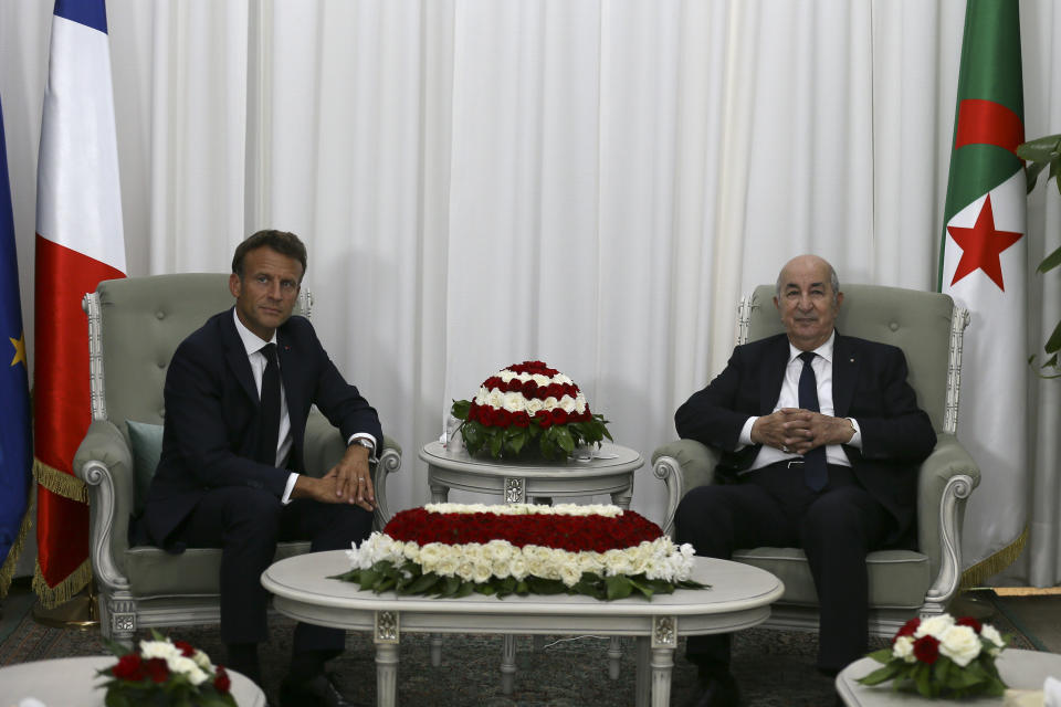 French President Emmanuel Macron, left, pose with Algerian President Abdelmajid Tebboune before their talks, Thursday, Aug. 25, 2022 in Algiers. French President Emmanuel Macron is in Algeria for a three-day official visit aimed at addressing two major challenges: boosting future economic relations while seeking to heal wounds inherited from the colonial era, 60 years after the North African country won its independence from France. (AP Photo/Anis Belghoul)