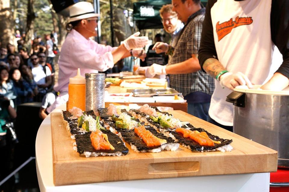 Chef Masaharu Morimoto teaching someone to make sushi