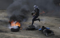 <p>Palestinian protesters burn tires during a protest on the Gaza Strip’s border with Israel, May 14, 2018. (Photo: Khalil Hamra/AP) </p>