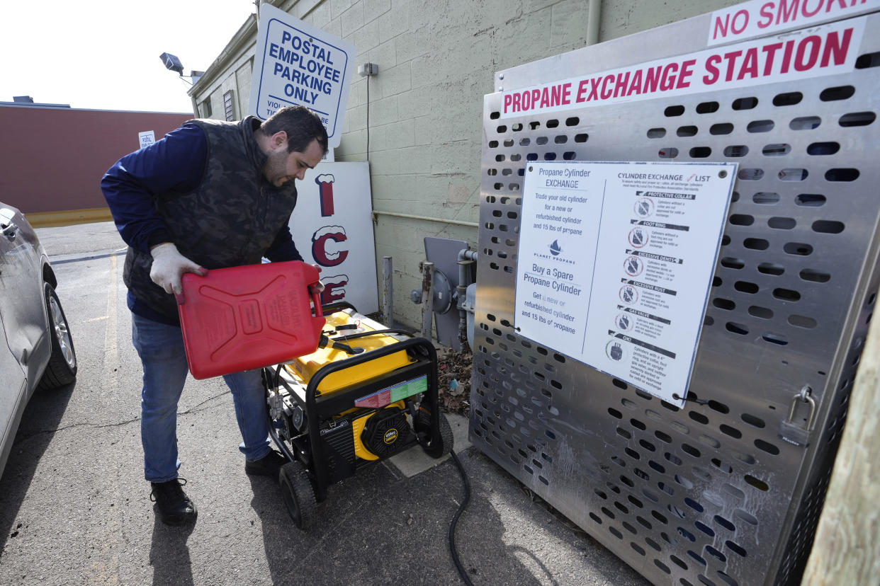Kevin Savaya, manager at Mr. C's Deli, fills a generator with gasoline to supply power to the business in Grosse Pointe Farms, Mich., Friday, Feb. 24, 2023. Michigan is shivering through extended power outages caused by one of the worst ice storms in decades. (AP Photo/Paul Sancya)