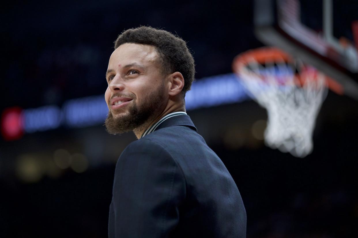 Golden State Warriors guard Stephen Curry smiles from the bench during the second half of an NBA basketball game against the Portland Trail Blazers in Portland, Ore., Monday, Jan. 20, 2020. The Trail Blazers won 129-124 in overtime. (AP Photo/Craig Mitchelldyer)