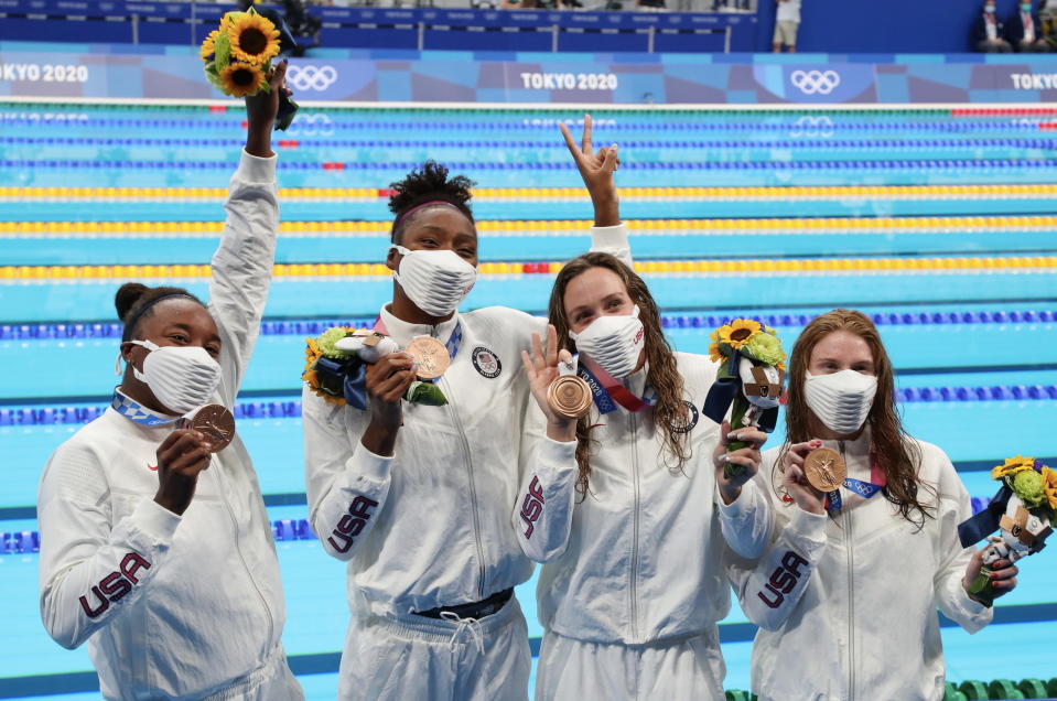 Erika Brown, Natalie Hinds, Abbey Weitzeil and Simone Manuel of Team United States celebrating their bronze medals near the pool