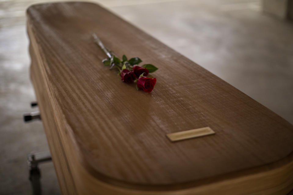 Flowers lie on the coffin of the last COVID-19 victim stored at an underground parking garage that was turned into a morgue, at the Collserola funeral home in Barcelona, Spain. May 17, 2020. A funeral home in Barcelona has closed a temporary morgue it had set up inside its parking garage to keep the victims of the Spanish city's coronavirus outbreak. The last coffin was removed and buried on Sunday. In 53 days of use, the temporary morgue has held more than 3,200 bodies. (AP Photo/Emilio Morenatti)
